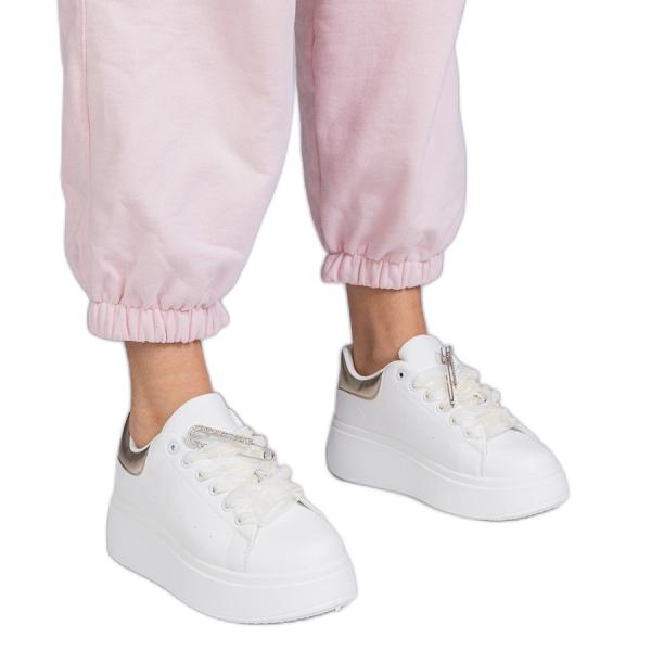 Białe sneakersy ze złotą wstawką i szpilką z cyrkoniami